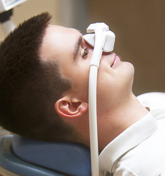Patient receiving dental sedation with nitrous oxide mask during treatment — relaxing and pain-free dentistry.