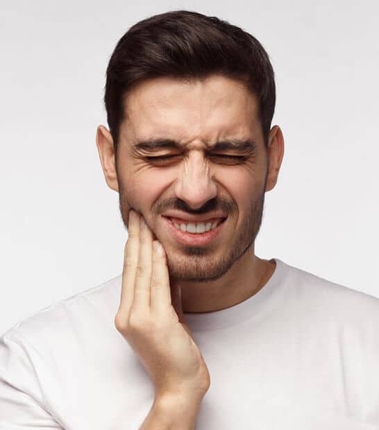 Man grimacing while touching his cheek, displaying tooth or jaw pain against white background.