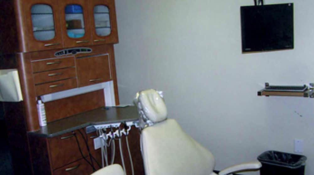 Private dental care room in Poway with ergonomic dental chair, wall-mounted monitor, and storage for instruments