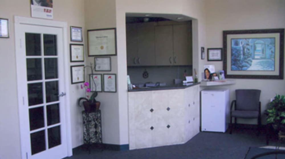 Reception area of a dental office in Poway featuring a welcoming front desk, framed certificates, and comfortable seating for patients.
