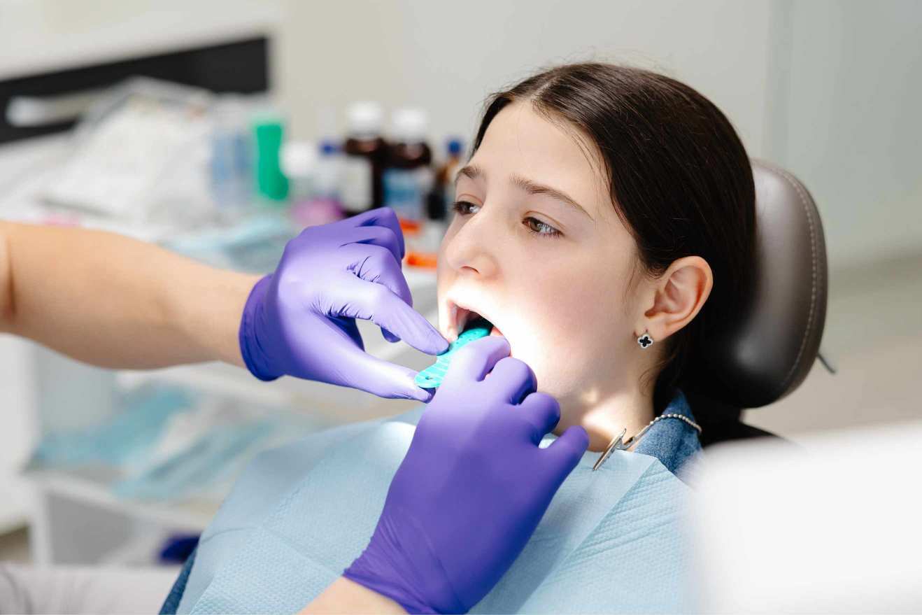 Dentist examining patient's teeth during oral examination in dental office.